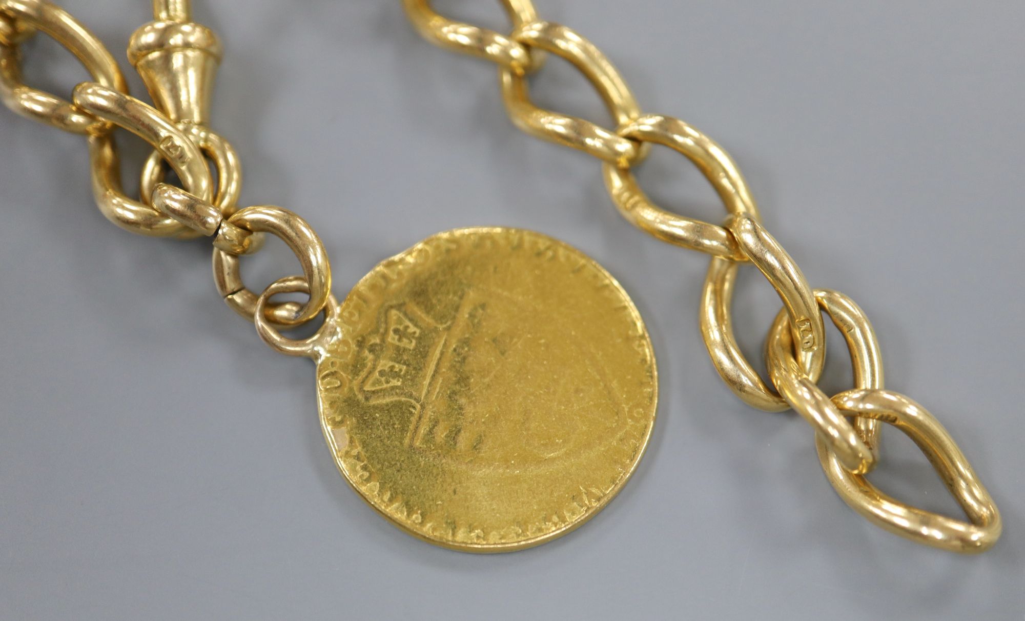 An 18ct gold curb link bracelet hung with a mounted spade guinea, bracelet 21.5cm,